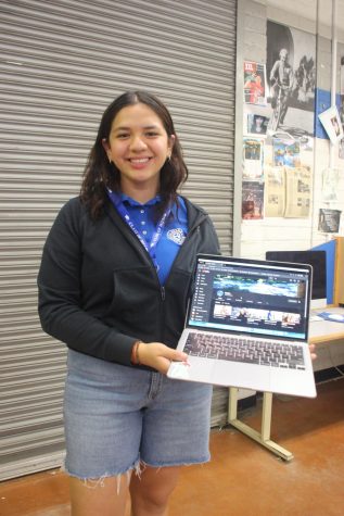 Senior Karla Lezama holding a computer with her Youtube channel Karla L.