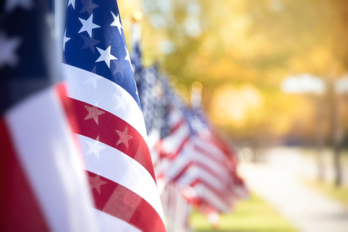 Closeup of an American flag in a row. Memorial day, Independence day, Veterans day, patriotic concept. Copy space.